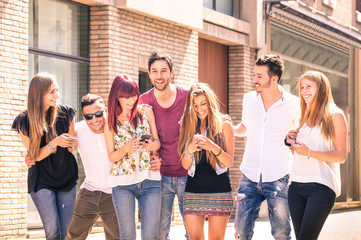 Group of young best friends having fun together walking on town street - Moment of technology...