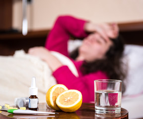 Sick woman lying at bed
