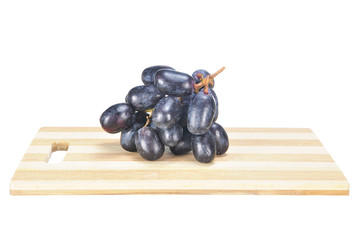 Delicious and fresh black seedless grape on chopping board isola