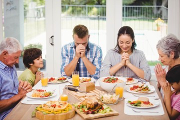 Family praying together before meal