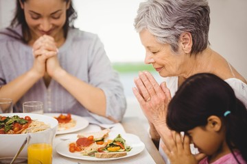 Family praying together before meal