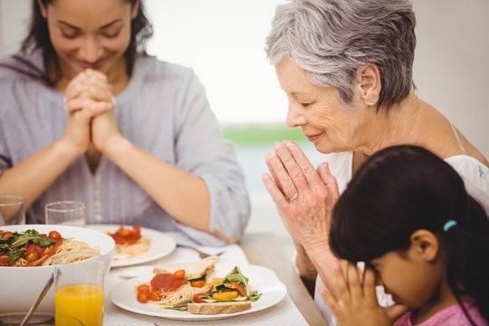 Family Praying Together Before Meal