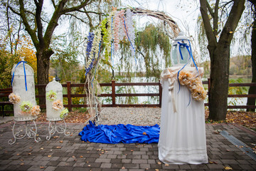 stylish decorated arch and tables with flowers and ribbons at th