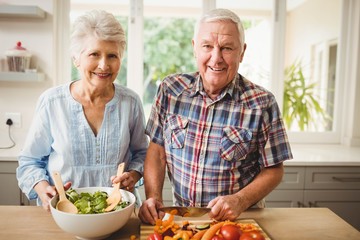 Senior couple preparing salad