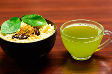 cups of green tea and noodles on wooden table