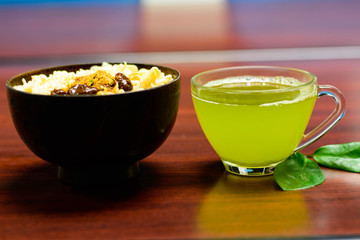 cups of green tea and noodles on wooden table
