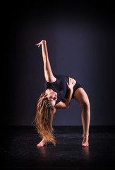 beautiful ballet dancer posing on black studio background