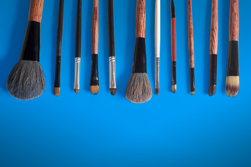 makeup brush and cosmetics, on a color background