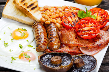 Full English breakfast with bacon, sausage, egg, beans and mushrooms
