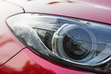 Xenon projector headlight of a red car