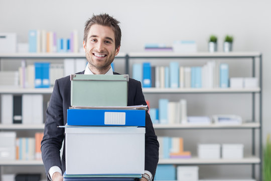 Businessman Carrying A Pile Of Boxes And Folders