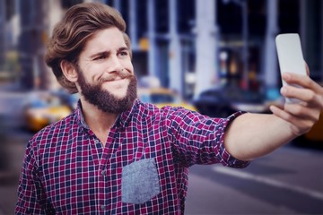 Composite image of hipster taking selfie against wooden wall