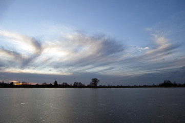 rozwiane chmury nad jeziorem