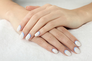 woman with manicure on white fluffy towel closeup