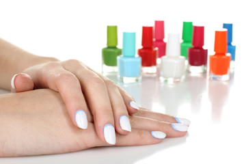 woman with manicure on white table. A lot of colorful nail Polish closeup
