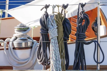 Fotobehang Zeilen Kleurrijke nautische accessoires met touwen, katrol en verchroomde lier op een goed uitgeruste houten zeilboot