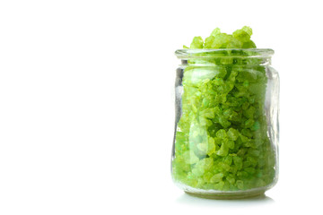 fragrant green sea salt lies in an open glass jar isolated on white background