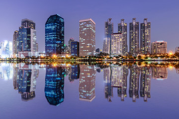 Bangkok skyline and water reflection with urban lake in summer.