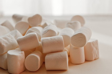 Fototapeta na wymiar beautiful little marshmallows scattered on a light background