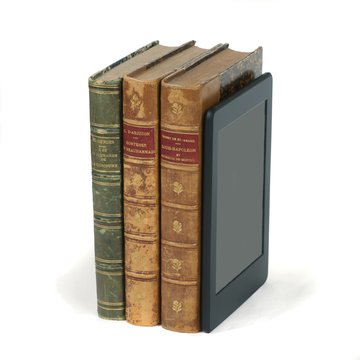 Electronic reader in a raw with old paper books