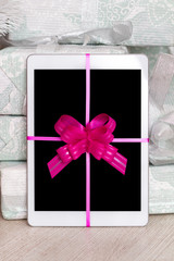 Digital tablet with red ribbon gift