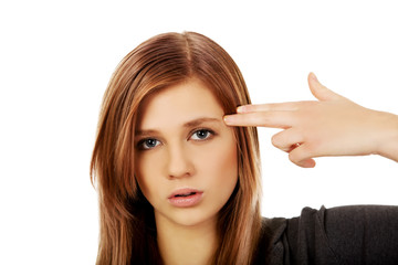 Teenage woman committing suicide with finger gun gesture