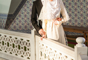 Happy islamic couple posing in front of mosque