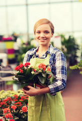happy woman holding flowers in greenhouse