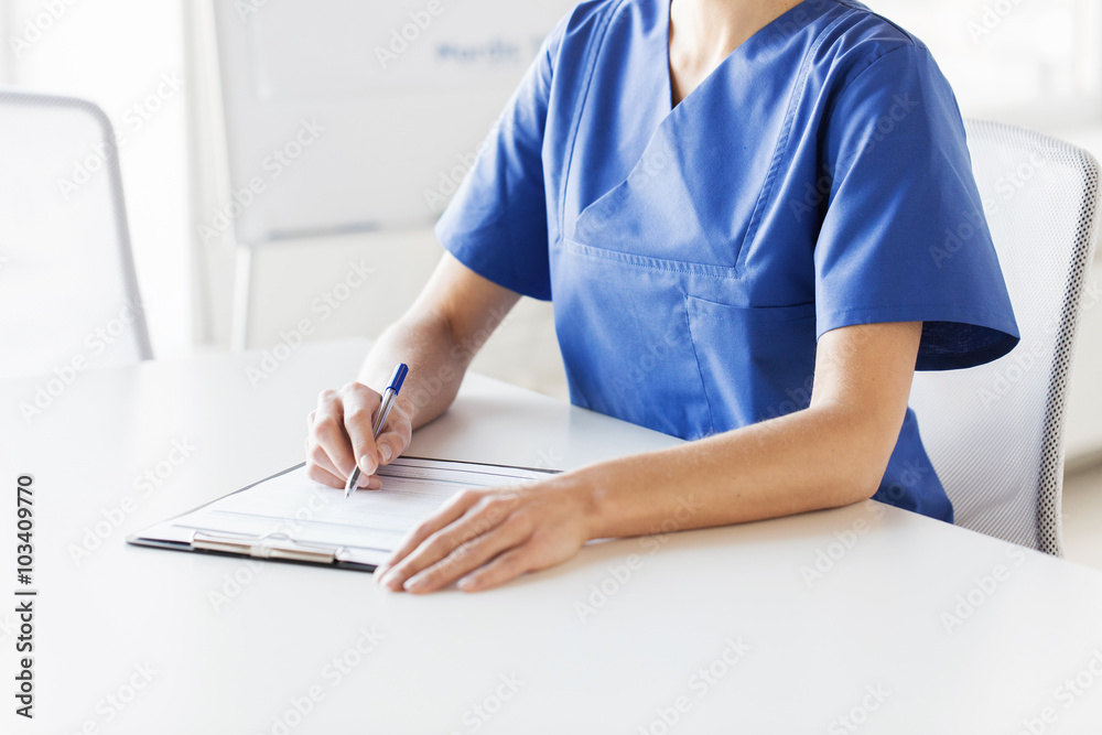 Wall mural close up of doctor or nurse writing to clipboard