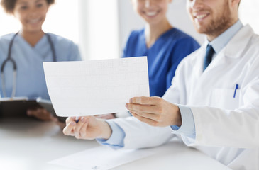 Fototapeta premium close up of doctors with cardiogram at hospital 