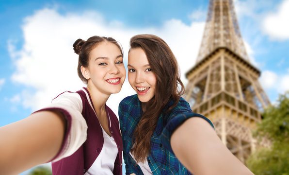 teenage girls taking selfie over eiffel tower