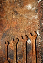 Old rusty wrench on dirty wooden table