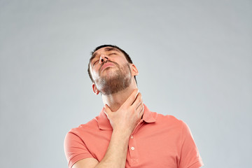 Fototapeta premium man touching neck and suffering from throat pain