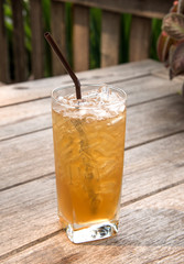 Glass tamarind juice with ice on wooden table