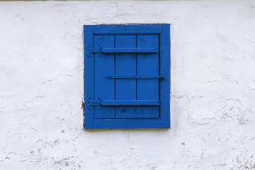 Obraz na płótnie Canvas Blue window with closed wooden blind