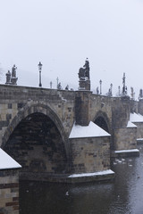 Obraz premium Snowy foggy Prague Charles Bridge with its baroque Sculptures, Czech Republic