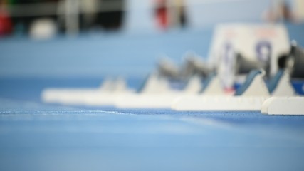 Athletes at the sprint start line in track and field competition
