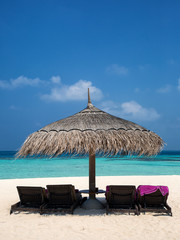 Sonnenschirm und Sonnenliege am Strand der Malediven