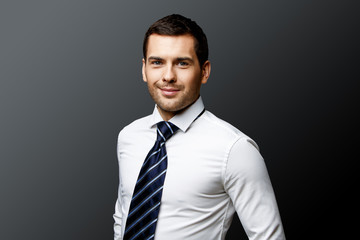 Handsome stylish businessman on grey background