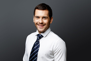 Handsome stylish businessman on grey background