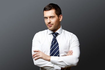 Handsome stylish businessman on grey background