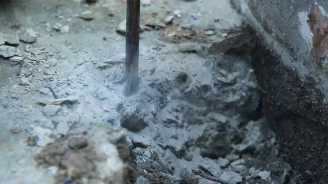 Unidentified Man with the drill breaking up asphalt on the road.