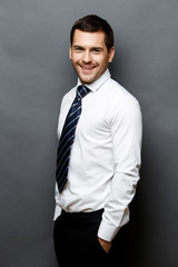 Handsome stylish businessman on grey background