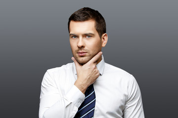 Handsome stylish businessman on grey background