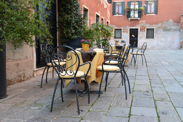 Tables et chaises sur une petite place à Venise