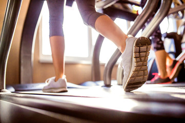 Detail of legs of woman running on treadmills gym