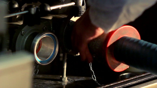 A worker connects a hose to the milk tank/Man attach hose to drain hole in truck