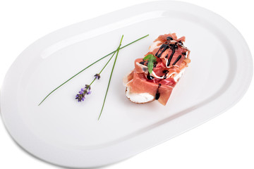 Prosciutto bruschetta with ricotta and arugula.