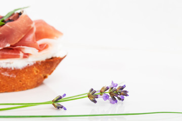 Prosciutto bruschetta with ricotta and arugula.