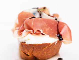 Prosciutto bruschetta with ricotta and arugula.